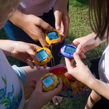 burys vaiku zaidzia su elektriniu zaidimu tamagotchi